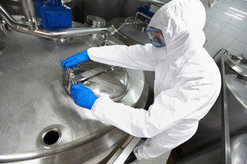 technician opening industrial process tank