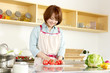© one - Beautiful young woman in kitchen making salad. Portrait of asian