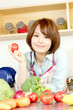 © one - Beautiful young woman in kitchen making salad. Portrait of asian
