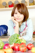 © one - Beautiful young woman in kitchen making salad. Portrait of asian