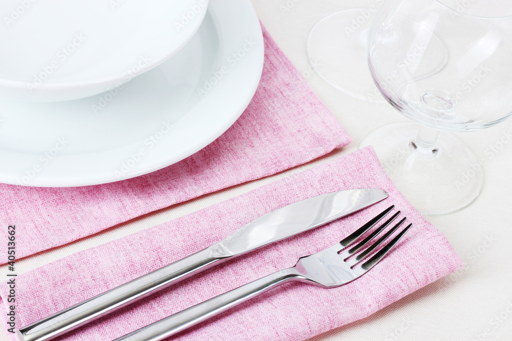 Table setting with fork, knife, plates and napkin