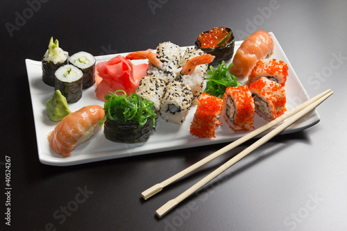 Board z aluminiowym obramowaniem Japońskie owoce morza sushi, rolki i chopstick na białym talerzu