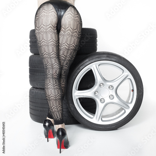 Fototapeta do kuchni Sexy woman with High Heels playing with set of summer tyres