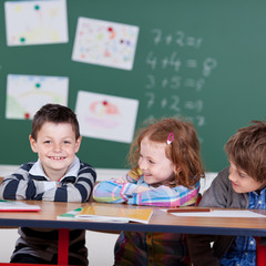 Wall Mural - drei lachende kinder in der grundschule