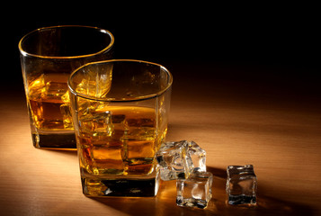 Poster - two glasses of scotch whiskey and ice on wooden table