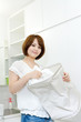 © one - Beautiful young woman doing laundry at home