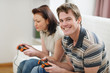 © Alliance - Young man playing on console with girlfriend