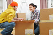 © Alliance - Moving young couple searching something in box