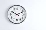 Silver shiny clock hanging at the wall with copy space