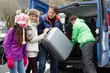 © Monkey Business - Family Unloading Luggage From Transfer Van Outside Chalet On Ski