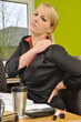 Junge Frau im Büro mit Nackenschmerzen
