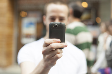 Men on street photographing with smart-phone