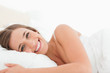 © WavebreakmediaMicro - Woman lying in bed with a bright smile