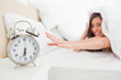© WavebreakmediaMicro - Woman under the quilt reaches for the clock