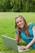 © WavebreakmediaMicro - Young girl looking at the camera while using her laptop and smil