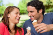 Two friends laughing while holding ice cream