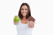 © WavebreakmediaMicro - Smiling woman holding a green apple and a piece of chocolate