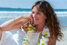 Woman Relaxing At The Beach Wearing A Lei