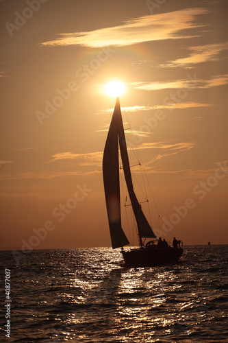 Fototapeta na wymiar Yacht and sails against the sunset sky