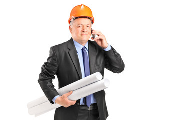 Sticker - Mature construction worker holding blueprints and talking on a p