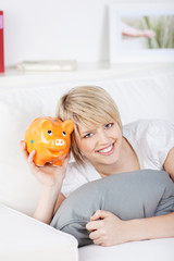 frau mit sparschwein auf dem sofa