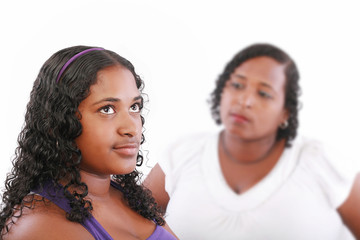 teenage girl with unhappy mother in the background