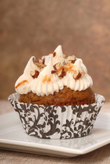 Wall Mural - Delicious carrot cake cupcake with cream cheese frosting and nut