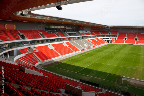 Naklejka dekoracyjna View on an empty football (soccer) stadium with red seats
