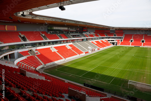 Obraz w ramie View on an empty football (soccer) stadium with red seats