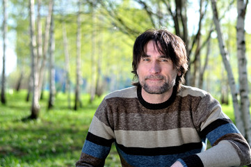 Middle-aged man in a birch grove