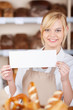 © contrastwerkstatt - bäckereiverkäuferin mit schild