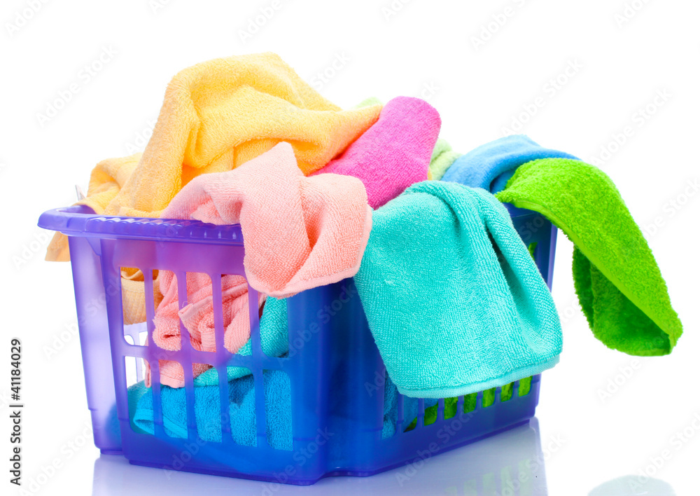 Plastic basket with bright towels isolated on white