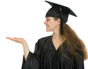 Wall Mural - Graduation student woman showing something on empty hand