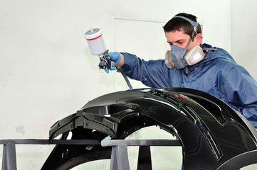 Man painting a black fender.