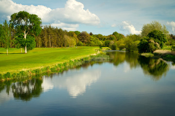 Idyllic golf course with reflection in the river