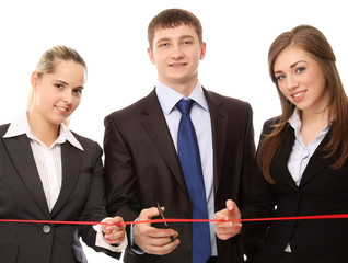 A businessman with scissors to cut the red ribbon