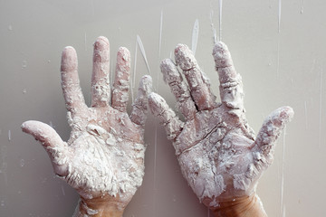 Astist plastering man hands with cracked plaster