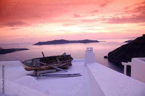 Board z aluminiowym obramowaniem Santorini z łodzi na białym dachu przed zachodem słońca w Grecji