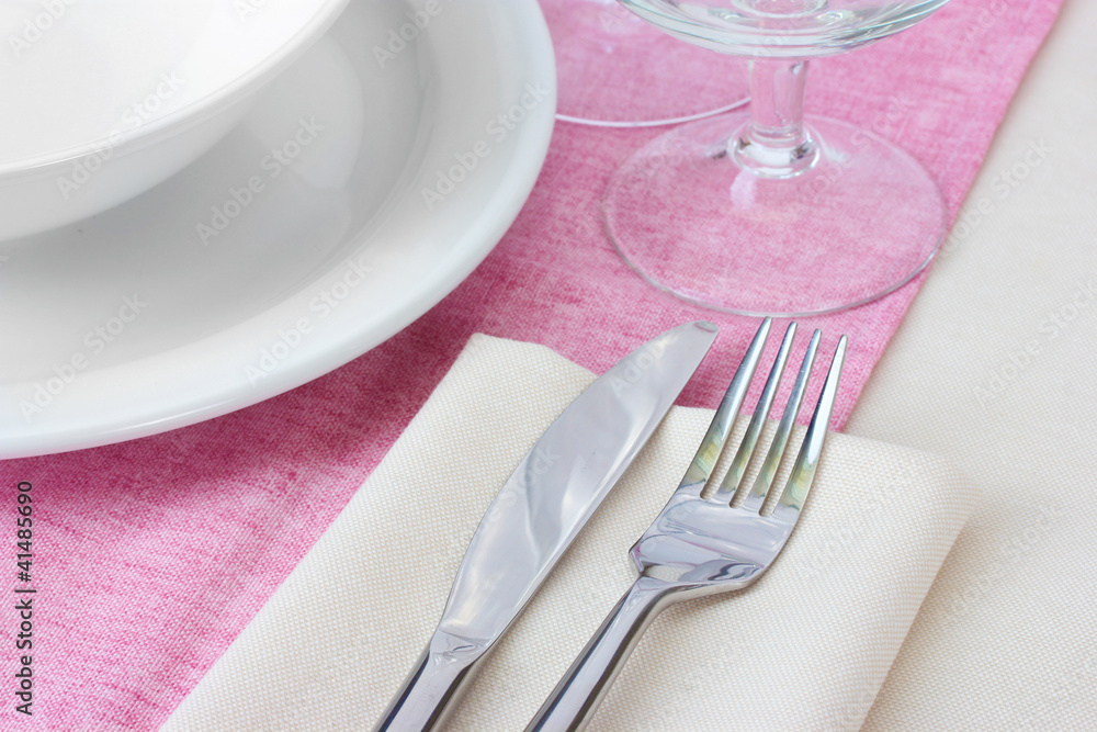 Table setting with fork, knife, plates and napkin