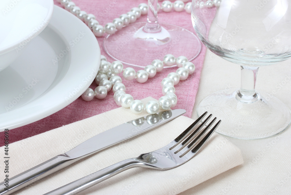 Table setting with fork, knife, plates, beads and napkin