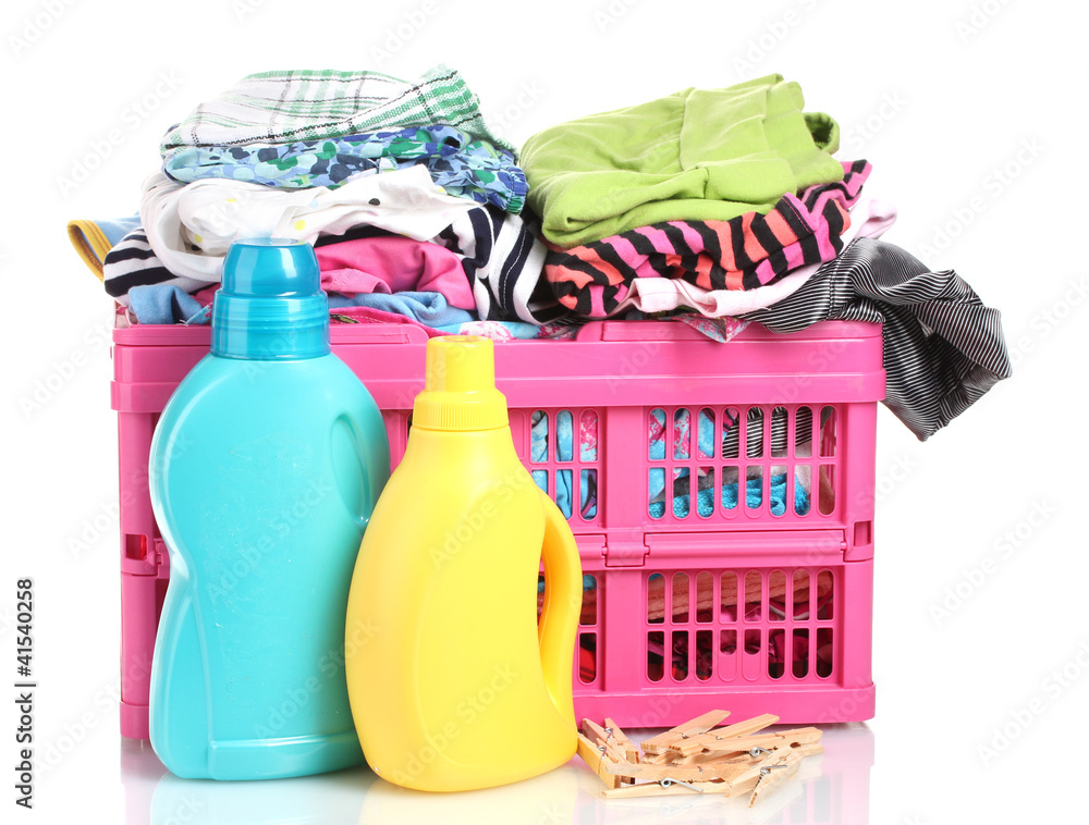 Clothes with detergent in pink plastic basket isolated on white