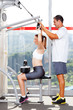 © michaeljung - fitness woman in gym with personal trainer