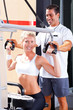© michaeljung - personal trainer helping client in gym