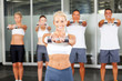 © michaeljung - group of people doing aerobics with dumbbells in gym