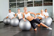 © michaeljung - group of people doing workout with gymnastic ball in a gym