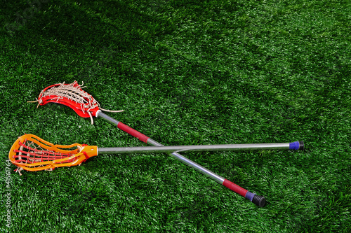 Board z aluminiowym obramowaniem Kije lacrosse na ziemi