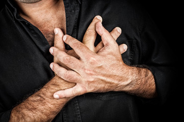 Chest pain concept - Two hands touching chest