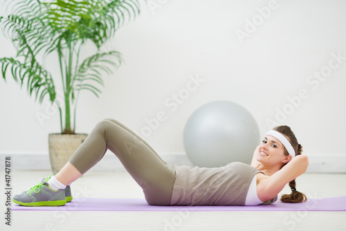 Naklejka na szybę Happy slim woman doing abdominal crunch