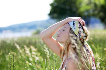 Beautiful blond woman in meadow with modern look