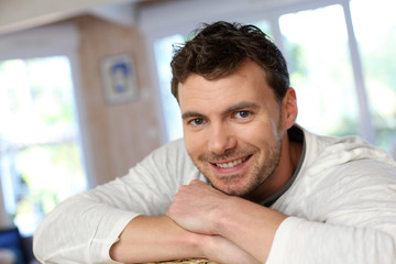 Portrait of young smiling man relaxing in sofa